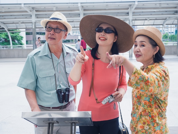 Elderly group walking in walk way in city,elder man and woman looking at map