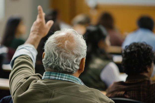 Elderly man actively participating in a classroom setting raising his hand to ask a question among younger students