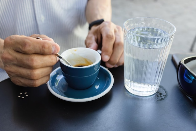 Elderly man drinking espresso coffee at an outdoor cafe