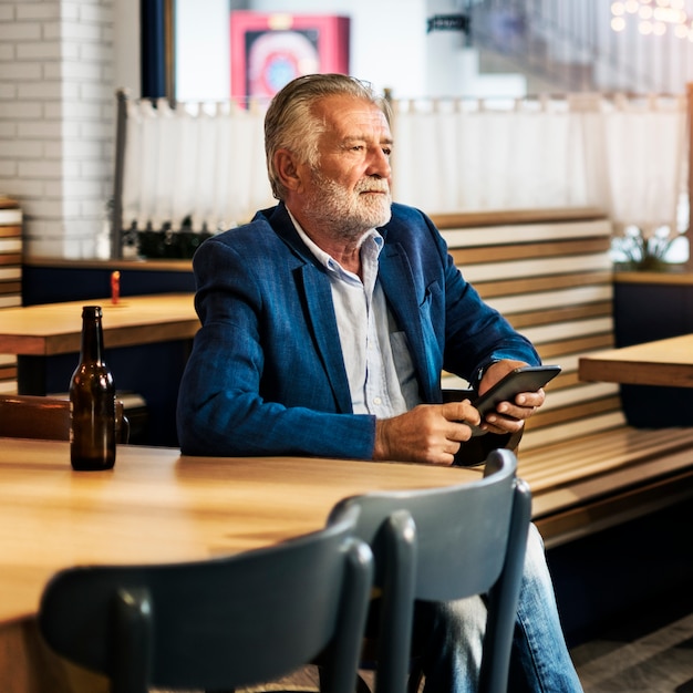 Elderly man is sitting in a pub