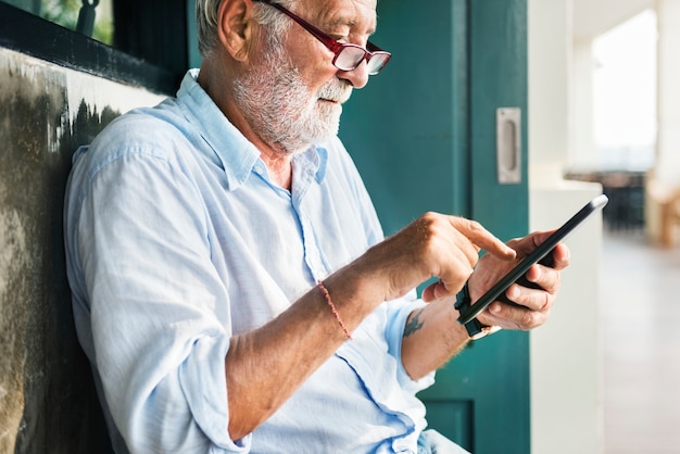 Elderly man is using digital tablet