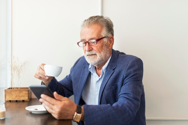 Elderly man is using digital tablet