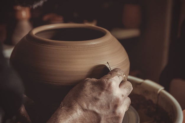 Elderly man making pot using pottery wheel 