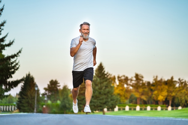 The elderly man running on the road