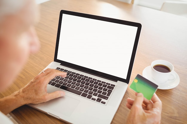 Elderly man spending money on internet at home