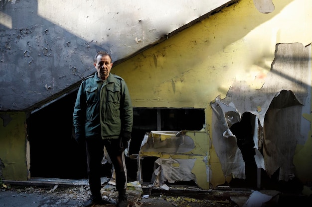 Elderly man standing in a destroyed city