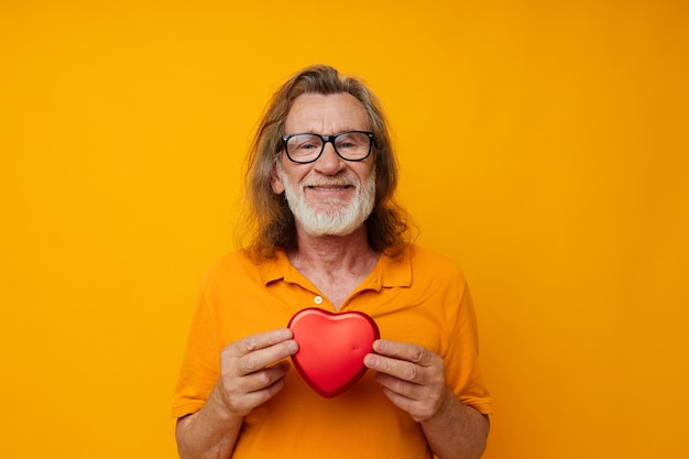 Elderly man in yellow glasses with a gray beard Red heart monochrome shot