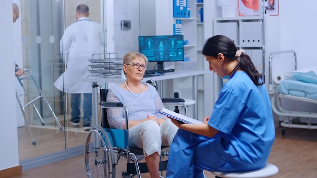 Elderly patient with walking disabilities in wheelchair seeking medical advice in recovery clinic or hospital. Senior handicapped woman health care support medical insurance paralyzed person