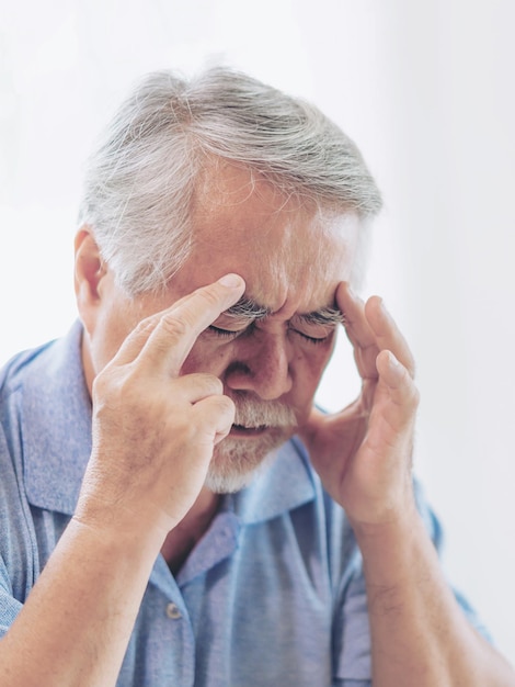 Elderly patients in bed Asian senior man patients headache hands on forehead medical and healthcare concept