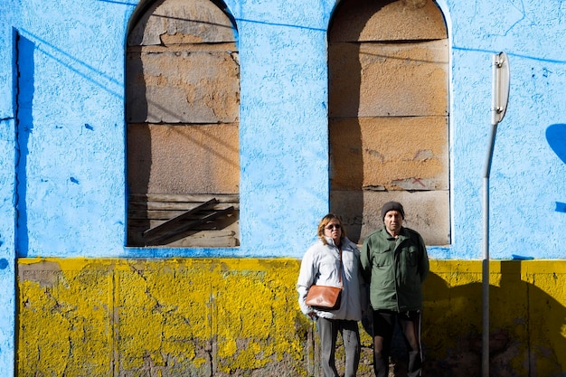 An elderly Ukrainian refugees standing by a ruined building