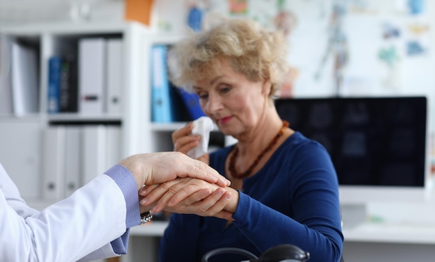 An elderly woman cries at doctors appointment