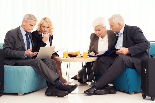 An elderly woman and an elderly man are sitting on the couch