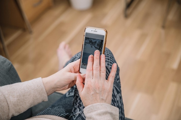 Elderly woman holding and using smartphone mobile phone Grandmother Close up view family connection conceptxA