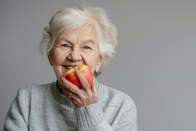 an elderly woman is holding an apple and wearing a sweater