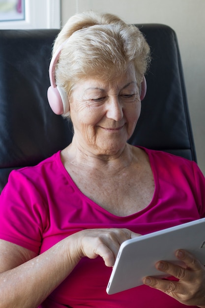 Elderly woman manipulating electronic devices for distraction and information