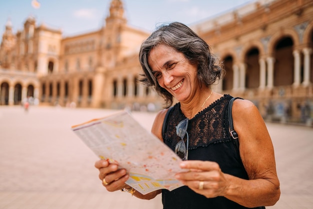 Elderly woman at the map to decide what to visit in the city Senior woman traveling in Europe