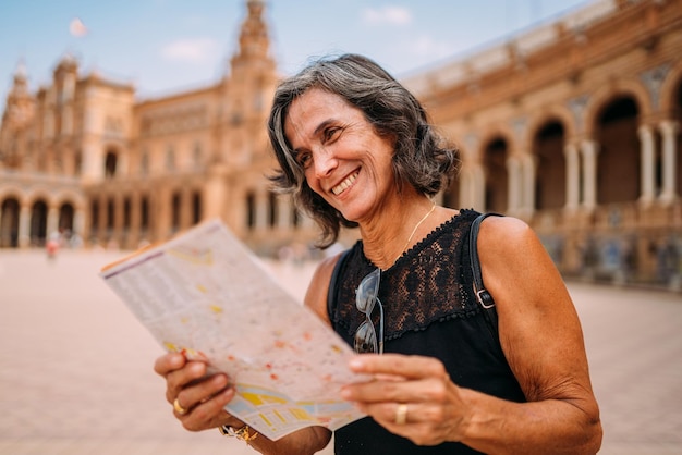 Elderly woman at the map to decide what to visit in the city Senior woman traveling in Europe