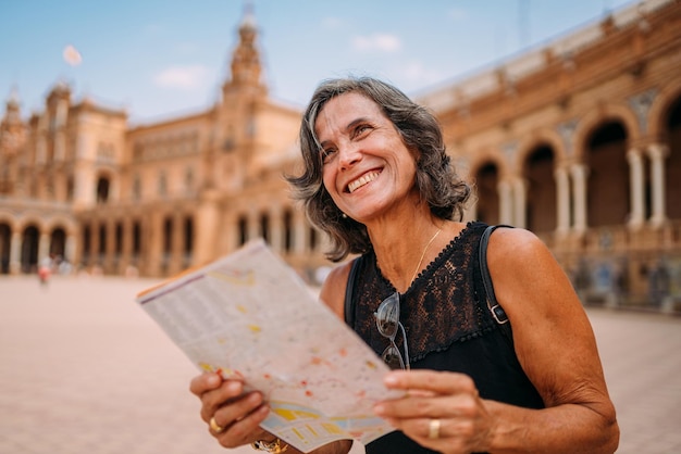 Elderly woman at the map to decide what to visit in the city Senior woman traveling in Europe