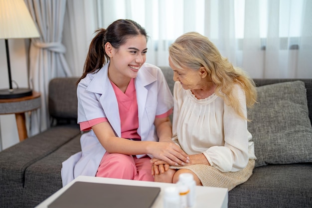 Elderly woman and nurse at home Healthcare worker girl cares about senior female person indoors