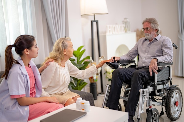 Elderly woman and nurse at home Healthcare worker girl cares about senior female person indoors