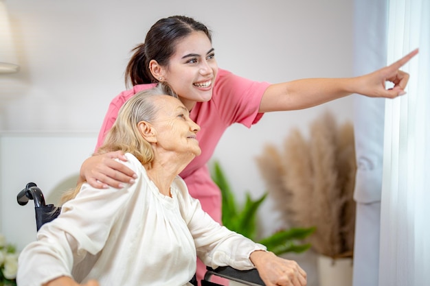 Elderly woman and nurse at home Healthcare worker girl cares about senior female person indoors