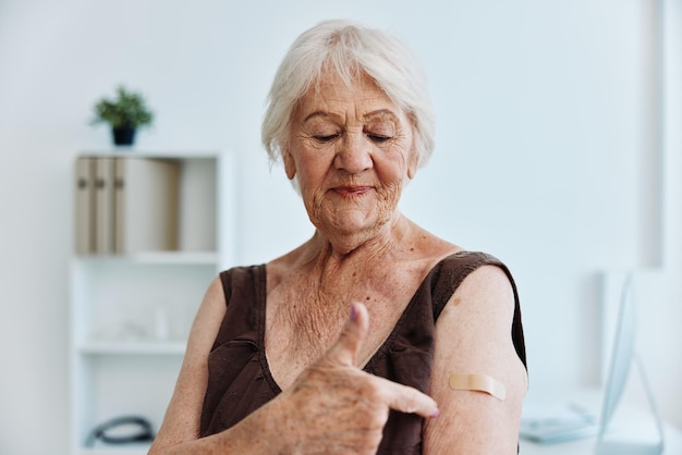 Elderly woman patch on shoulder vaccine passport immunity protection