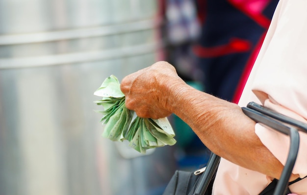 An elderly woman's hands holding money