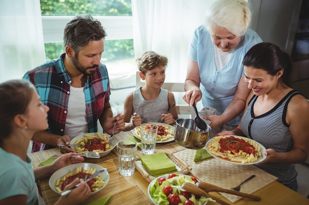 Elderly woman  serving meal to her family