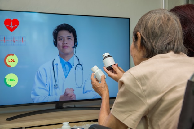 Elderly woman sit at home having online consultation with doctor.