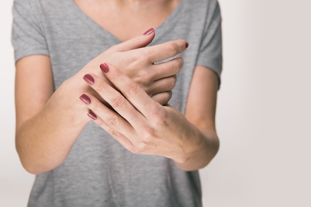 Elderly woman suffering from pain, weakness and tingling in wrist. Causes of hurt include osteoarthritis, rheumatoid arthritis, gout or wrist sprain. Health care concept