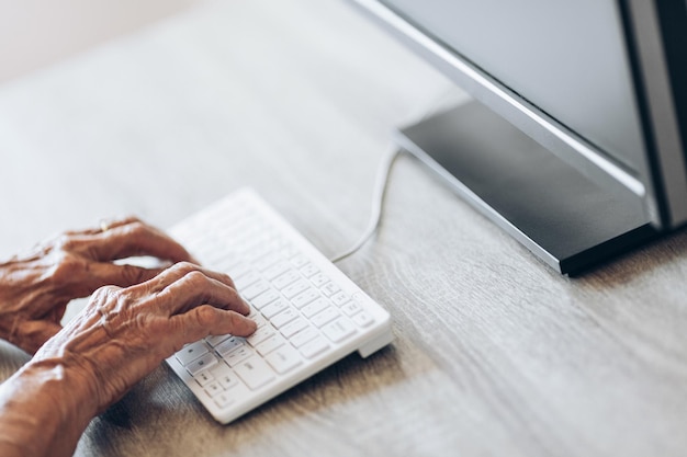 Elderly woman typing on a keyboard