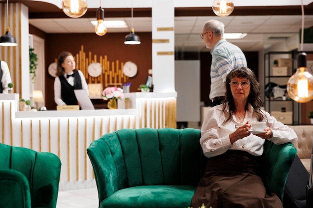 Elderly woman waits on sofa in hotel