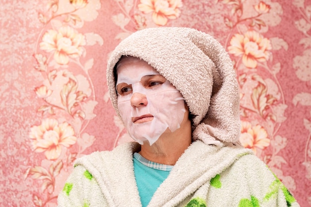 An elderly woman with a cosmetic mask on her face Skin care