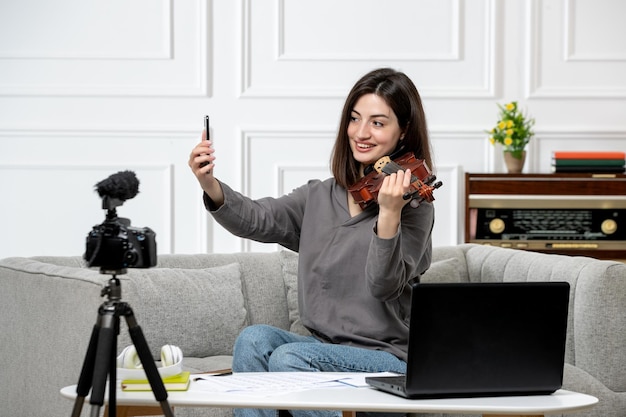 Elearning cute young beautiful girl remotely at home giving violin classes