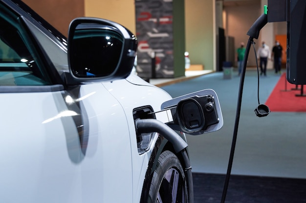 An electric car is plugged in at a charging point for electric vehicles