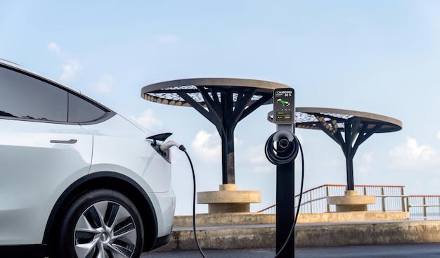 Electric car recharging battery at outdoor EV charging station for road trip or car traveling by the seascape alternative and sustainable energy technology for ecofriendly car Perpetual