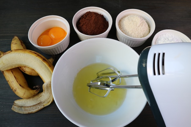 Electric Egg Beater in Mixing Bowl of Egg White Surrounded with Another Ingredients