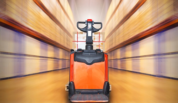 Electric Forklift Pallet Jack in Blurred Warehouse Shipping Warehouse Tall Shelf Storage Supplies