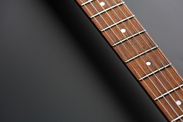 Electric guitar, closeup view on wooden fretboard, nobody. String musical instrument, electro sound, electronic music, equipment for stage concert