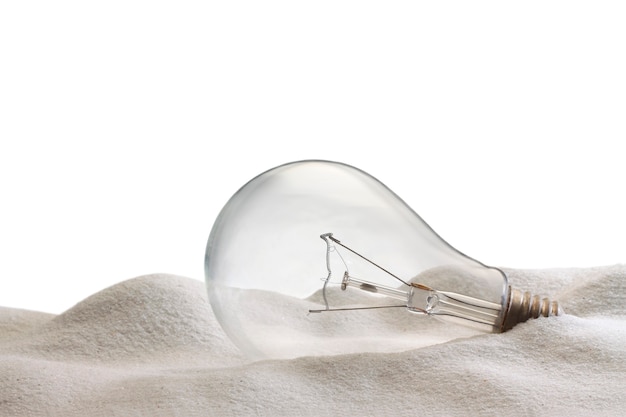 Electric lamp bulb  on sand and white background