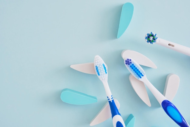 Electric and plastic toothbrushes on a blue background which brushes are more effective in cleaning the oral cavity