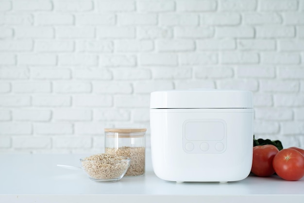 Electric rice cooker on wooden countertop in the kitchen