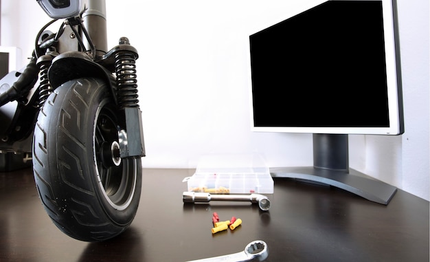 Electric scooter on a bench in a specialized workshop near the monitor Maintenance service concept