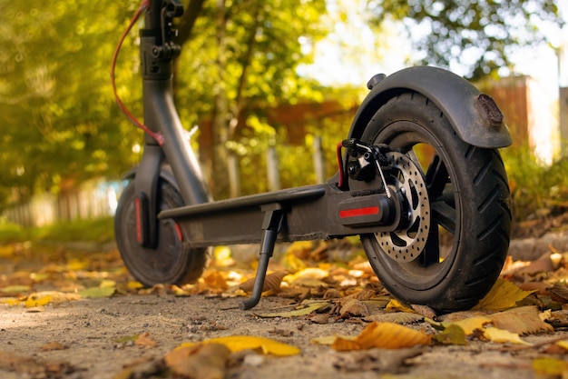 Photo electric scooter in yellow autumn leaves closeup