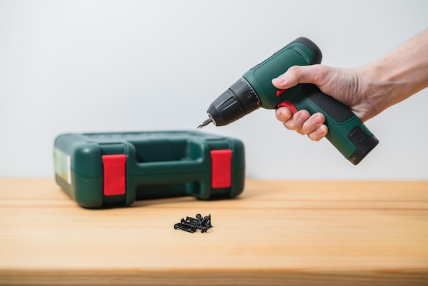 Photo electric screwdriver in a man's hand on a white background as well as on a tree background