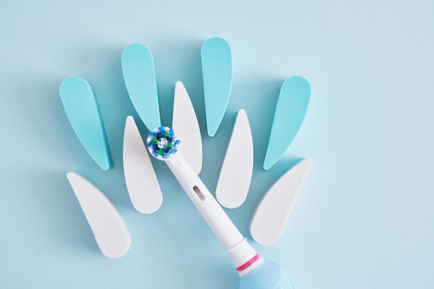 Electric toothbrush on a blue background which brushes are more effective in cleaning the oral cavity