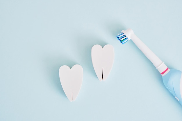 Electric toothbrush on a blue background which brushes are more effective in cleaning the oral cavity