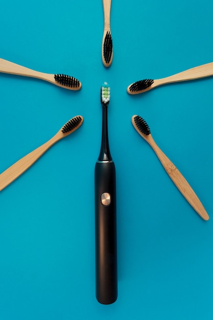 Electric and wooden toothbrush on blue background