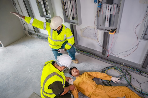 Electric worker suffered an electric shock accident unconscious. Safety team CPR for first aid Electric worker loses in electric shock accident at work on site. Accident in control room of factory.