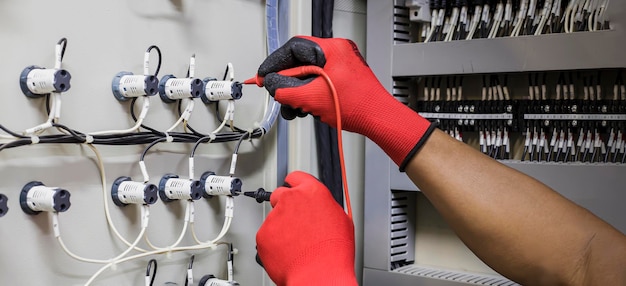 Electrical engineer checking the operation of electrical control cabinet, maintenance concept.